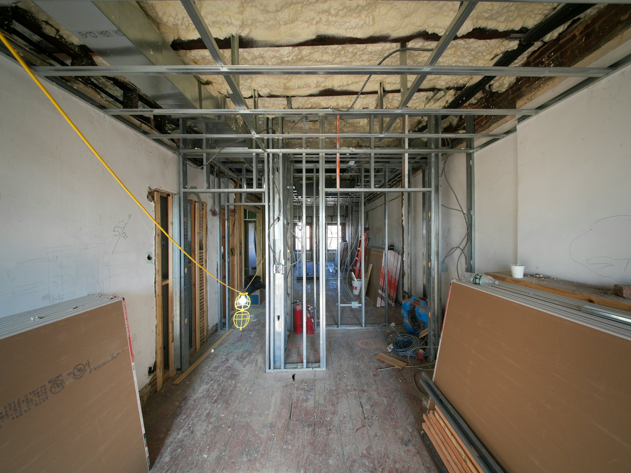 Interior under construction with metal studs and drywall sheets